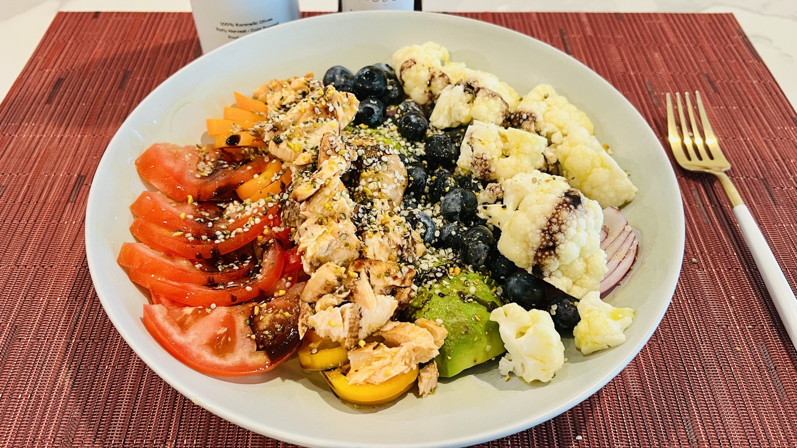 토마토, 생선살, 블루베리, 콜리플라워, 아보카도, 적양파를 색깔별로 담은 무지개색 샐러드